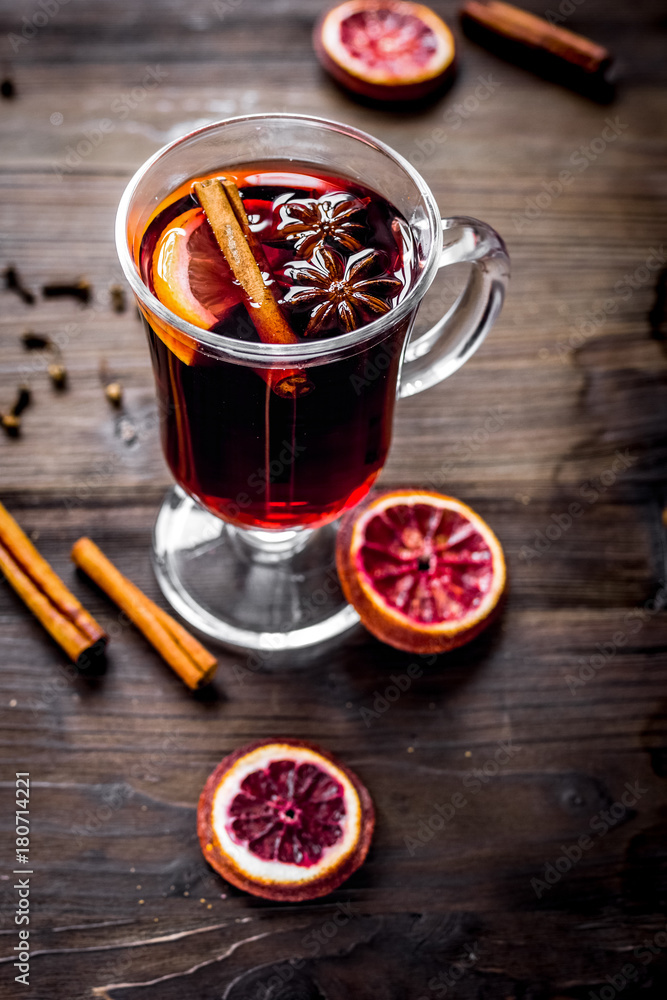 mulled wine with spices in cup on wooden background