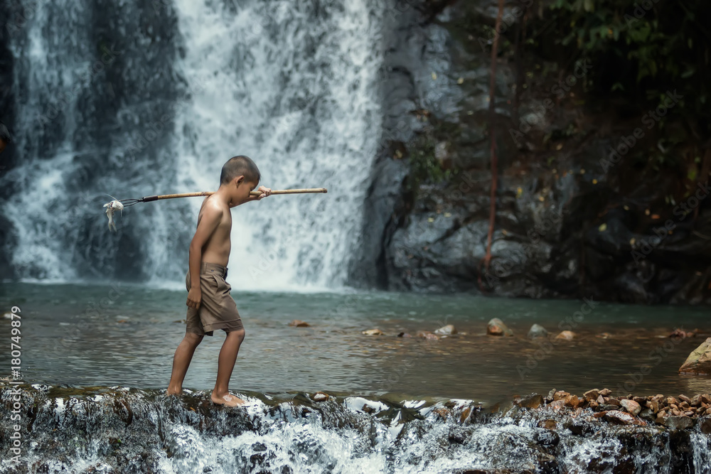 Asian boys fishing in the river at countryside Thailand.