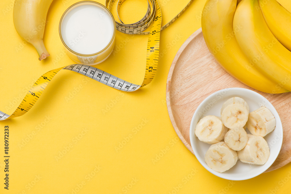 Healthy lifestyle concept - banana smoothie, measuring tape