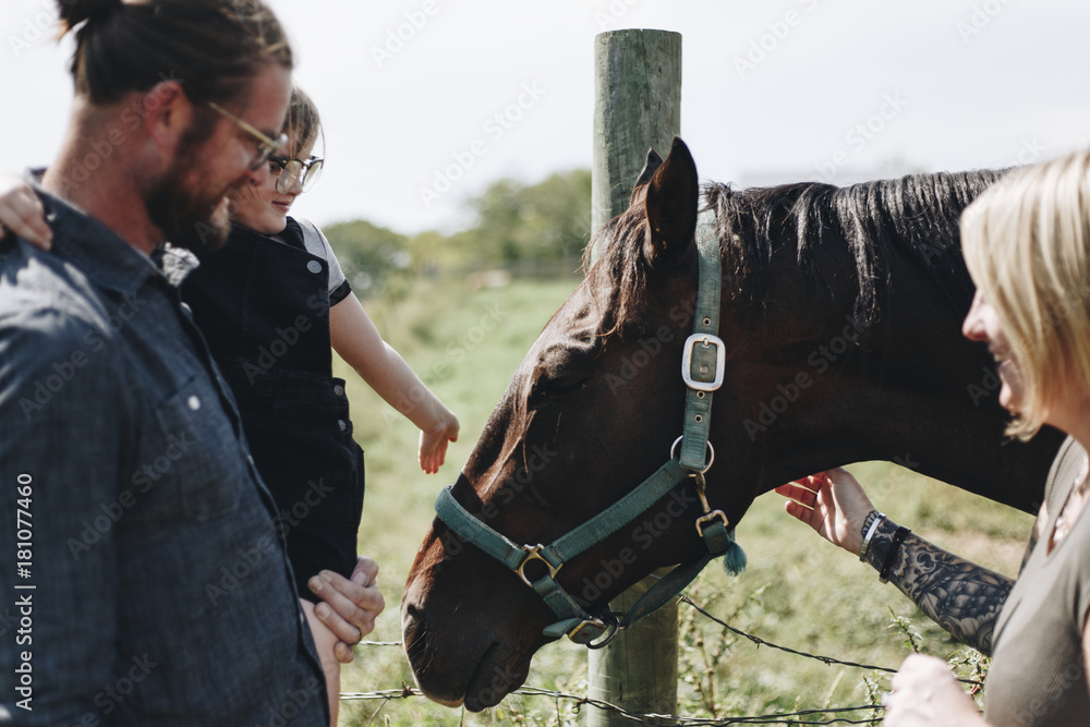 Young girl and family with a horse in the farm