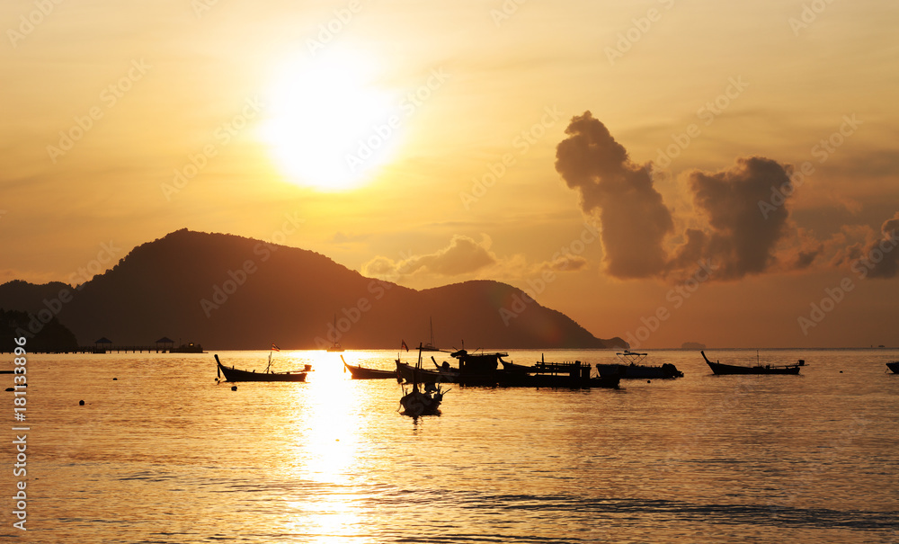 美丽的日出海景，船在普吉岛的拉威海滩。