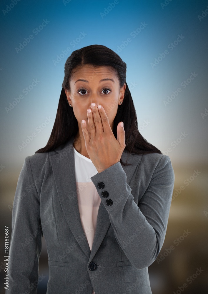 Businesswoman covering mouth with hand in city