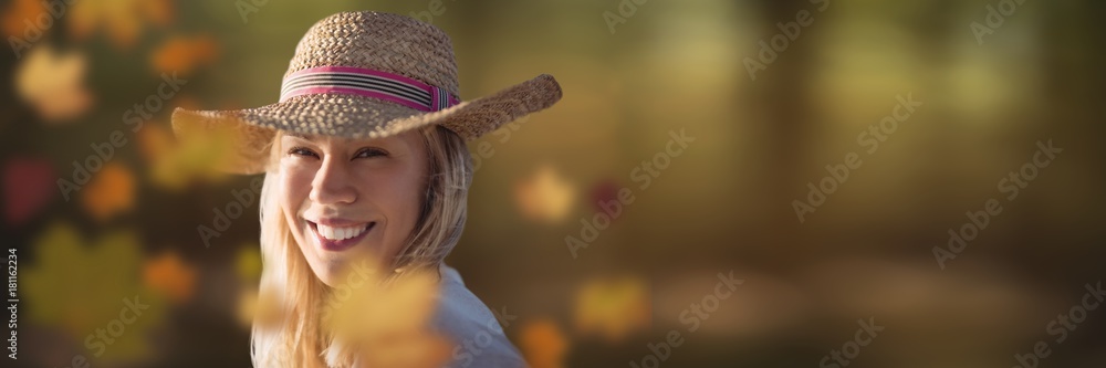 Woman wearing hat in forest with leaves