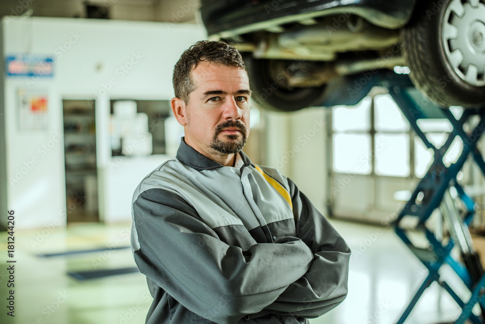 Portrait of a middle aged car worker in his shop.