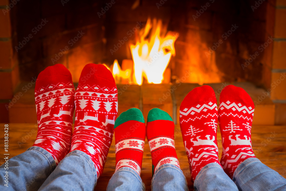 Family in Christmas socks near fireplace