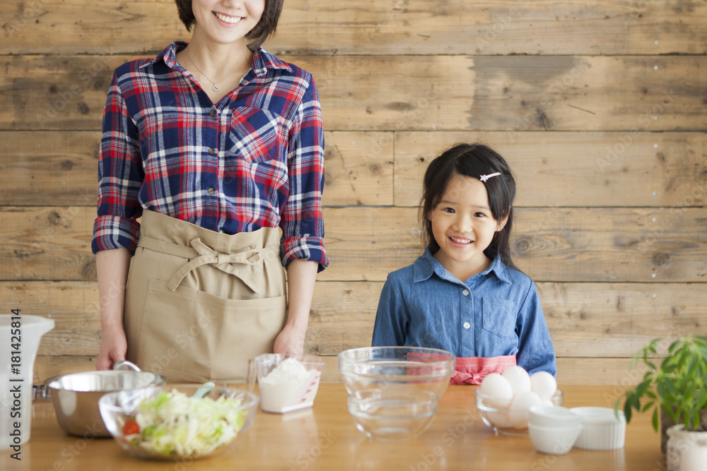 母亲和女儿在家做饭。