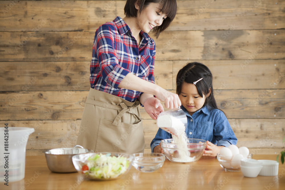 母亲和女儿在家做饭。