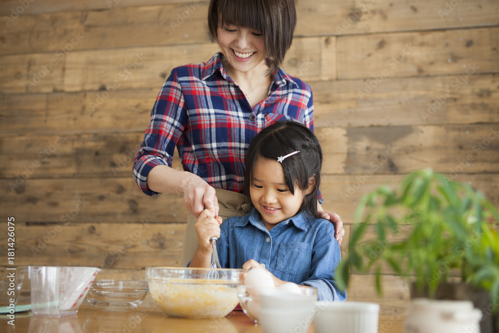 母亲和女儿在家做饭。