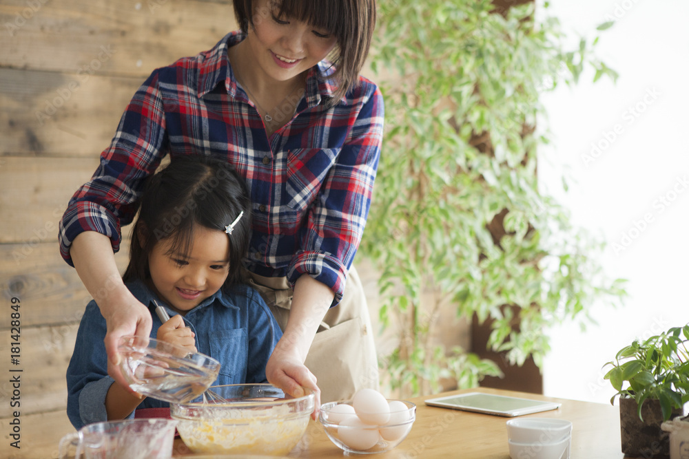 Mother and child daughter girl are cooking sweets and having fun in the kitchen.