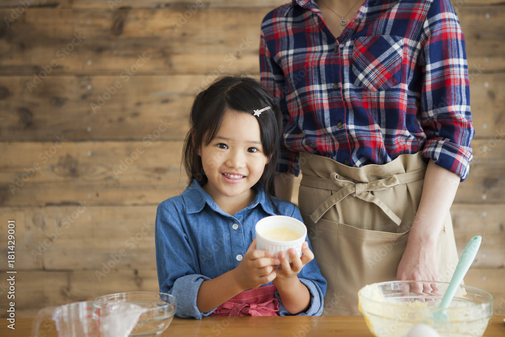 Mother and child daughter girl are cooking sweets and having fun in the kitchen.