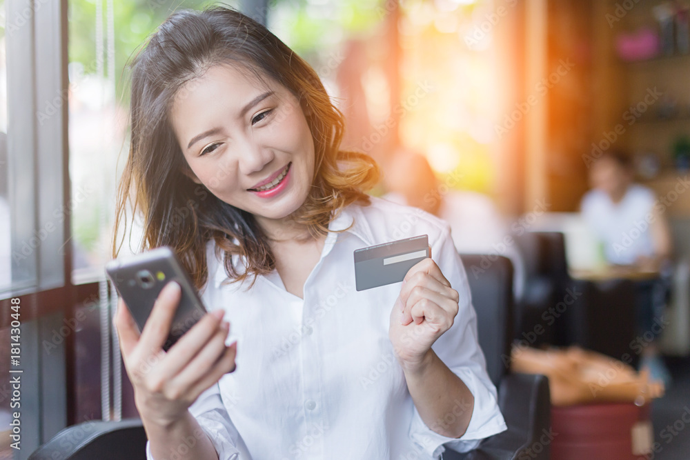 business asian girl in white shirt with credit card and smartphone onine shopping ideas concept with