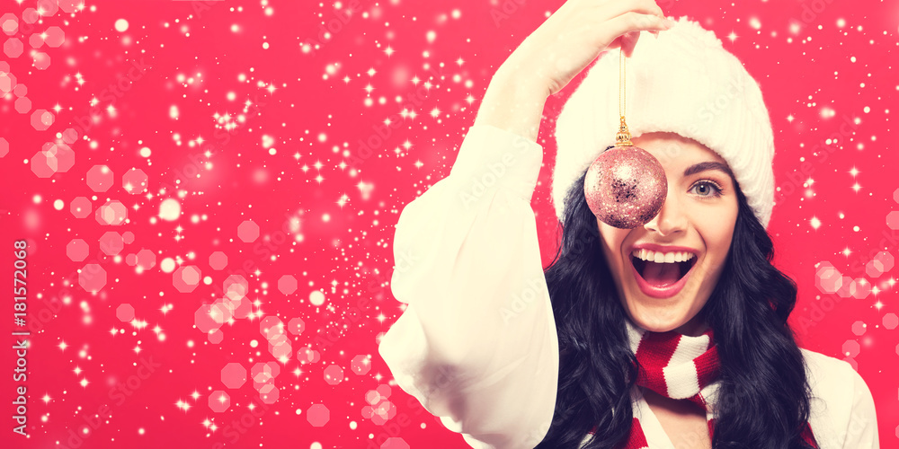 Happy young woman holding a Christmas bauble