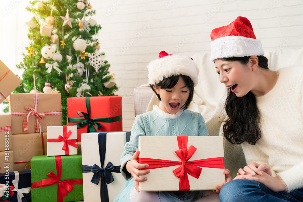 little daughter opens the gift with her mother