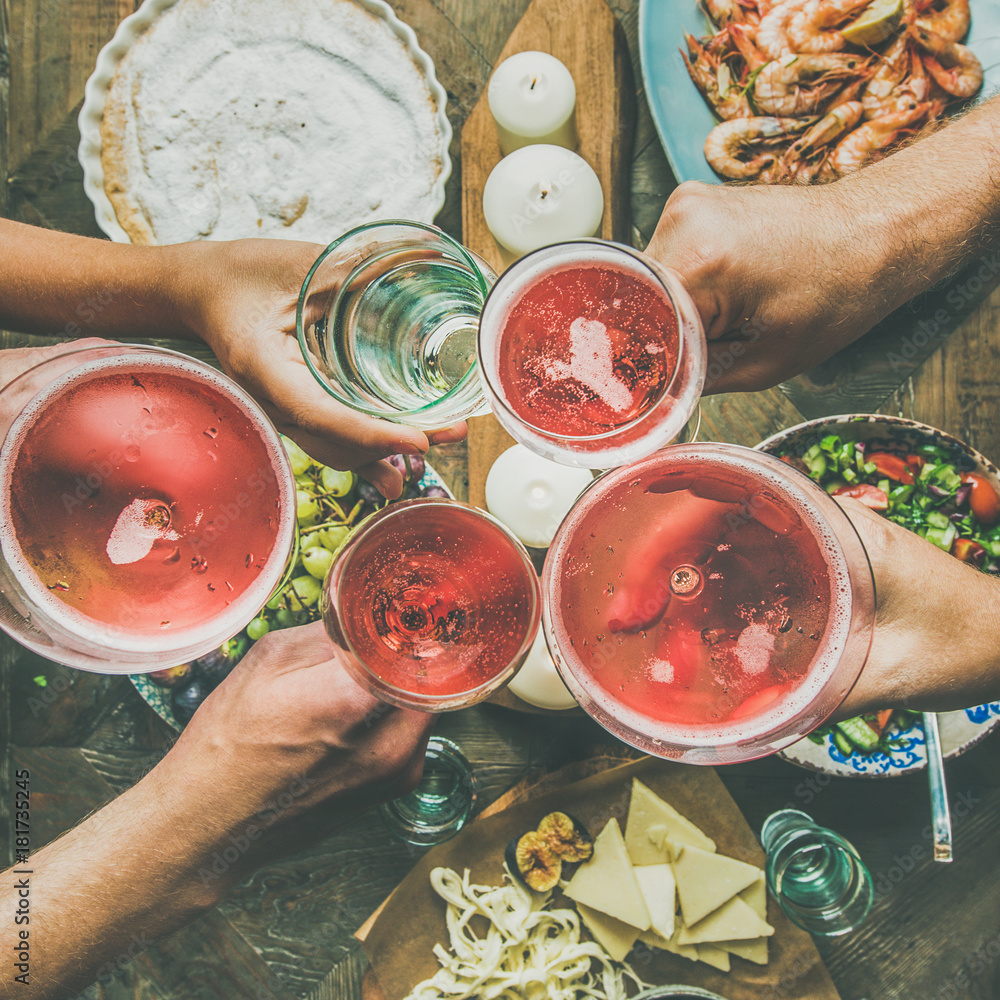 Holiday celebration table setting with food snacks. Flat-lay of friends hands eating and drinking to