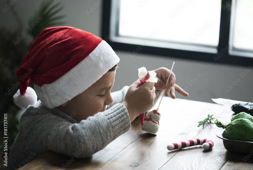 Little boy decorating a snowman marshmallow