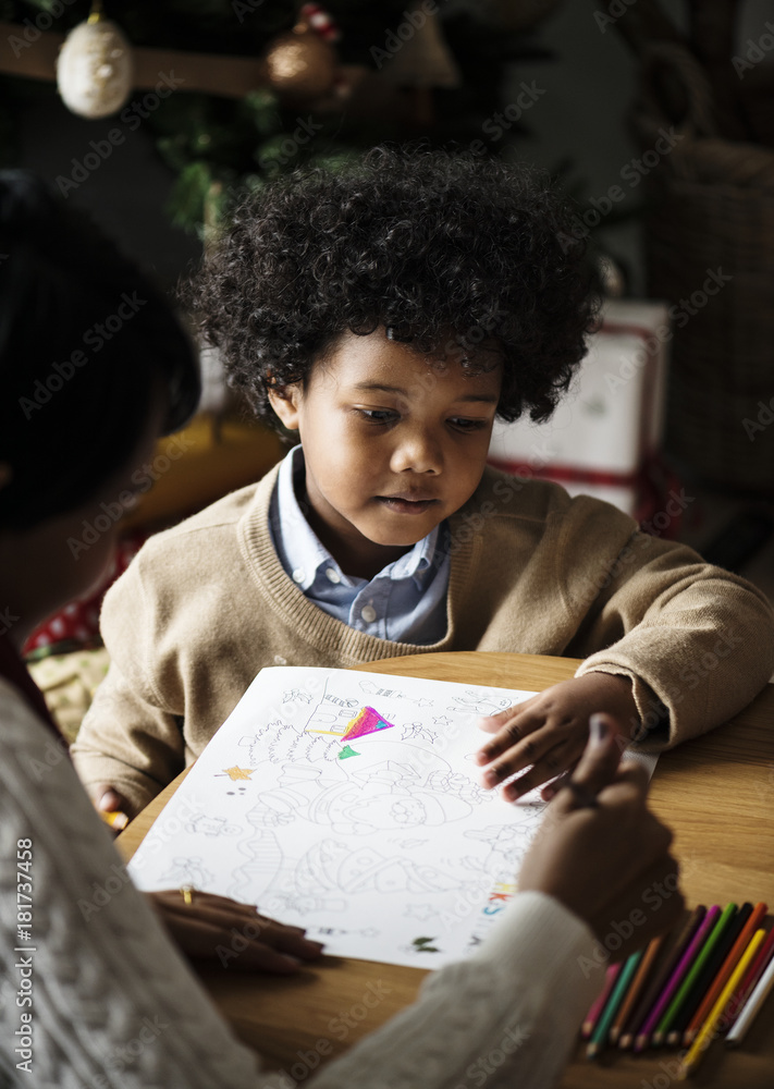 African kid enjoying a coloring book