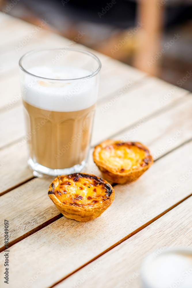 户外餐桌上的葡萄牙咖啡加甜甜点pastel de Nata