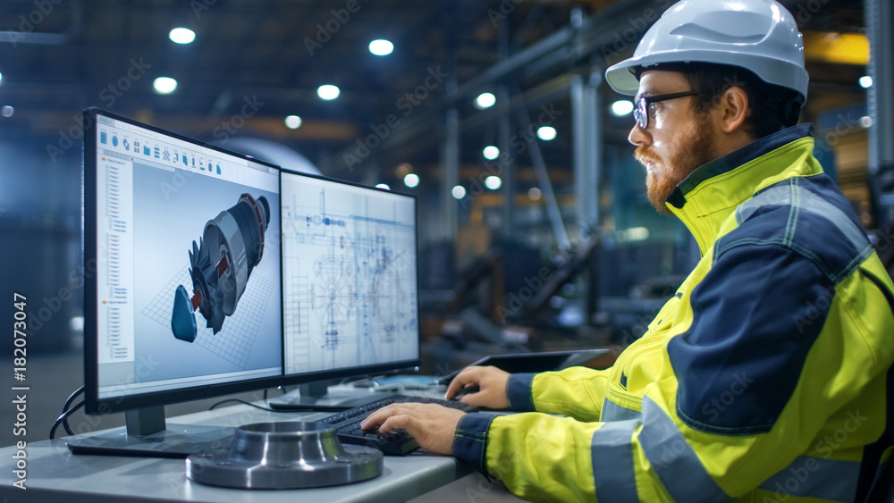 Inside the Heavy Industry Factory Industrial Engineer Works on the Personal Computer Designing Turbi