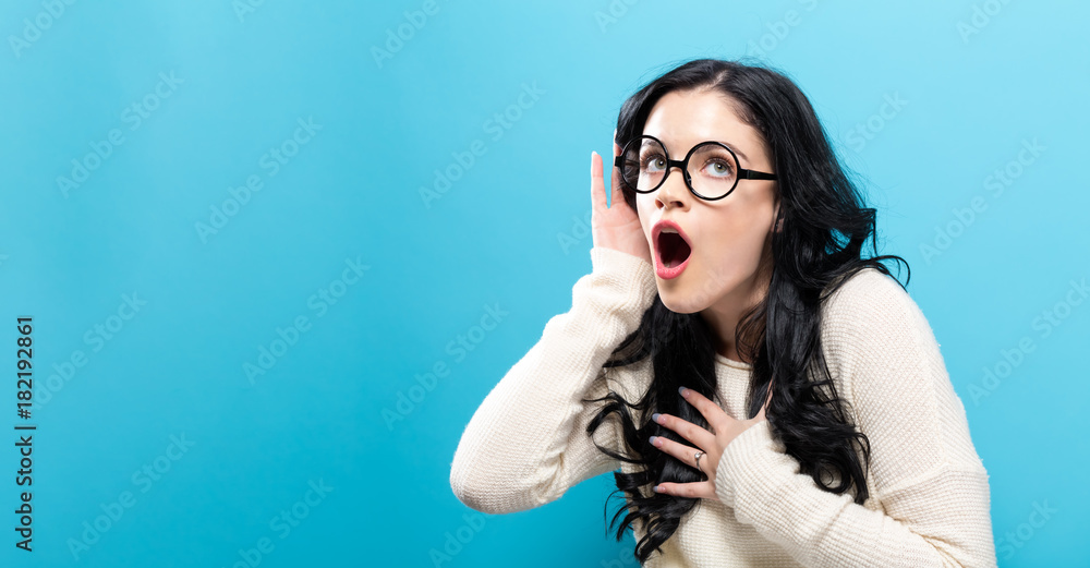 Young woman listening to something on a solid background