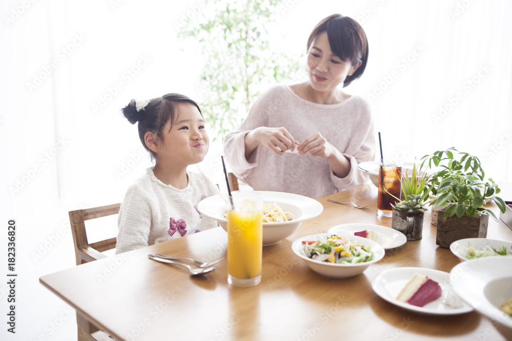 Dad, mommy and daughter are eating pasta.