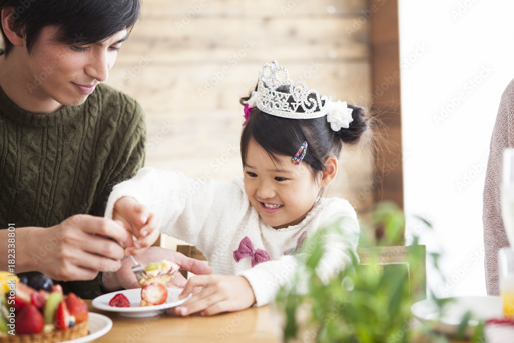 爸爸和妈妈正在庆祝她女儿的生日。