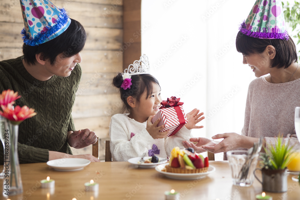 爸爸和妈妈给女儿送生日礼物。