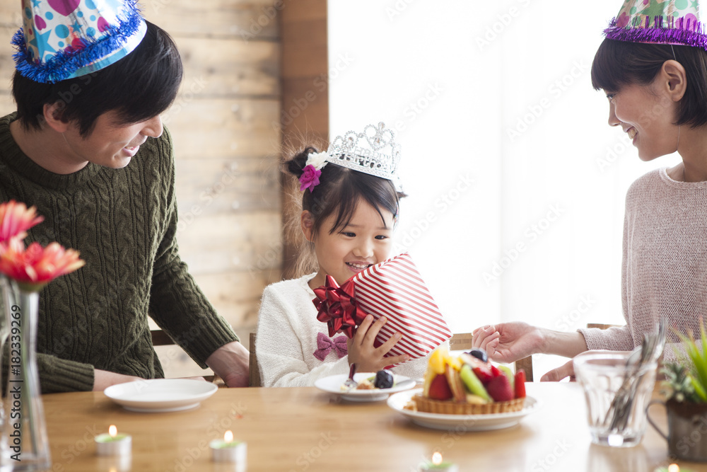 爸爸和妈妈给女儿送生日礼物。