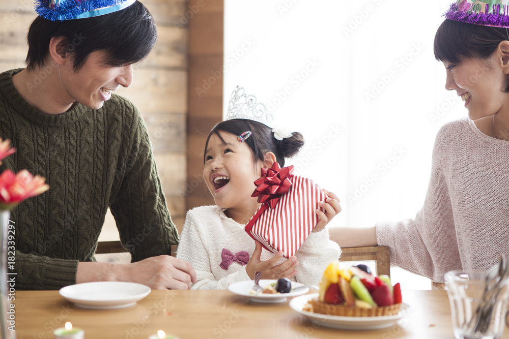 Dad and mommy give birthday present to her daughter.