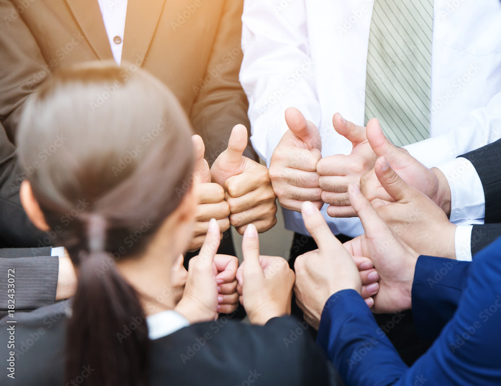 Business people give thumbs up sign