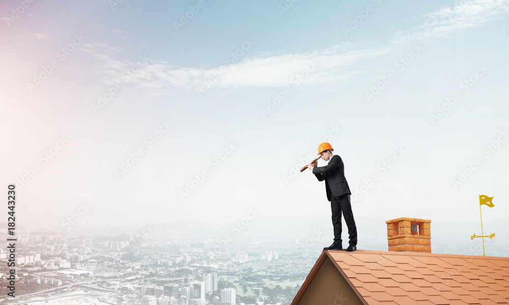 Engineer man standing on roof and looking in spyglass. Mixed media