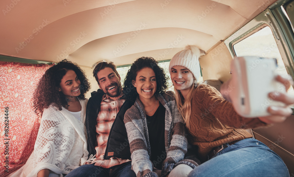 Friends making a selfie in the van