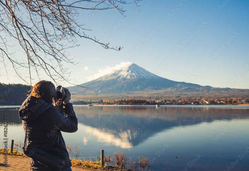 亚洲女旅行者在日本河口湖富士山拍照的背影