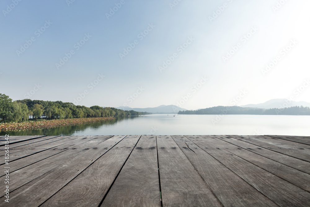 empty wooden floor with beautiful lake in blue sky