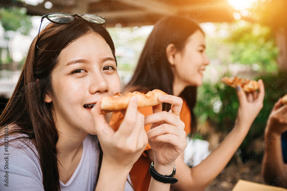 Asian students eating eating the pizza together in breaking time early next study class having fun a