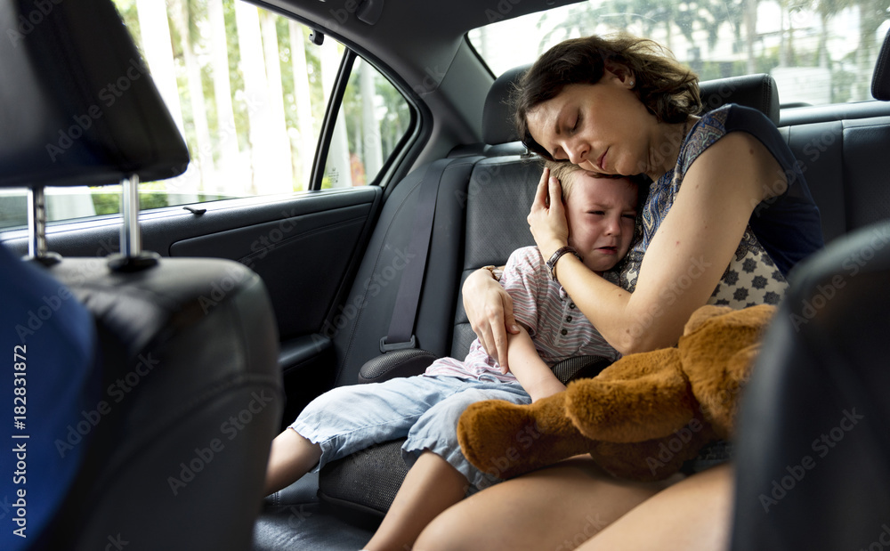 Mother consoling her crying son in the car