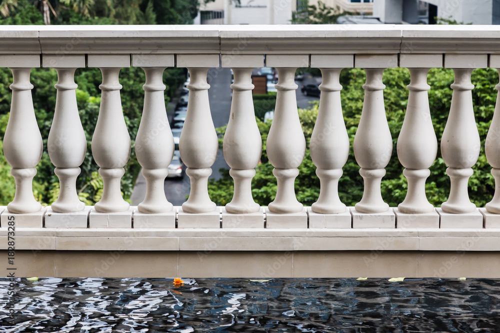 white stone design fence next to blue swiming pool