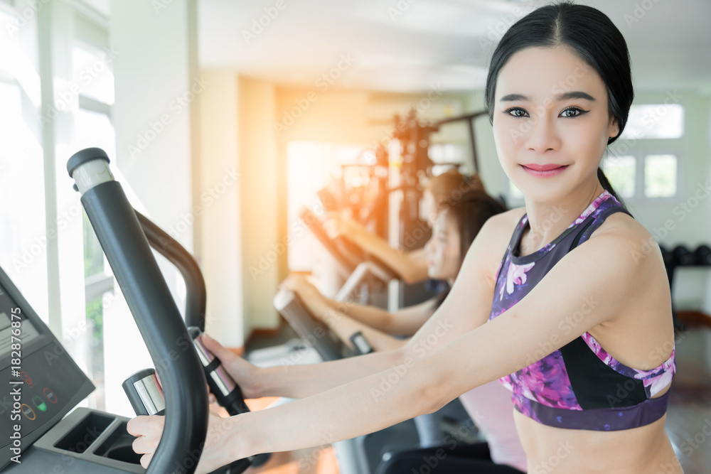 asian sport woman enjoy workout with treadmill in gym fitness center with group of people