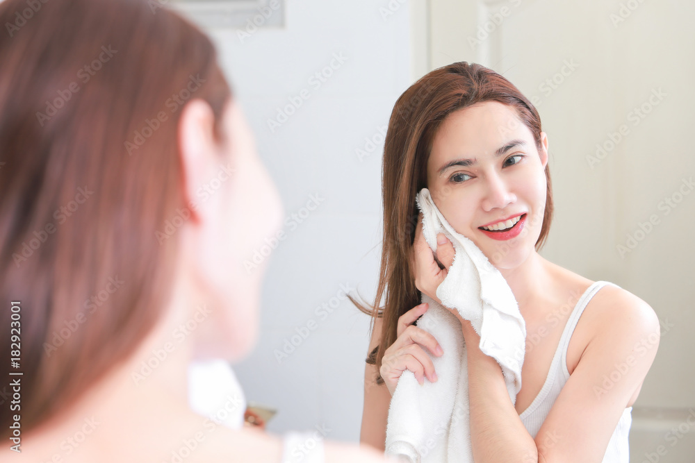 Woman cleaning washing on her face with clean water in bathroom.