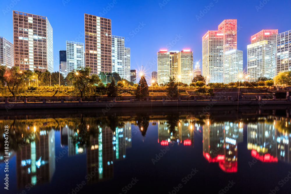 Business district office buildings and water reflection in Beijing at night