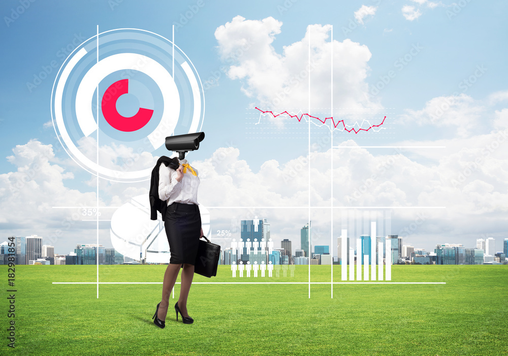 Camera headed woman standing on green grass against modern cityscape