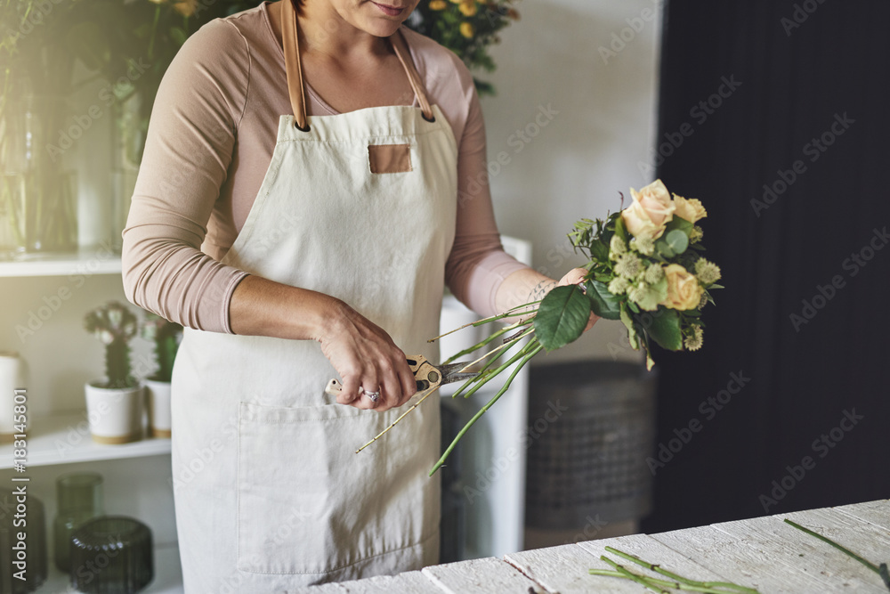 在花店工作的女花匠正在修剪花束