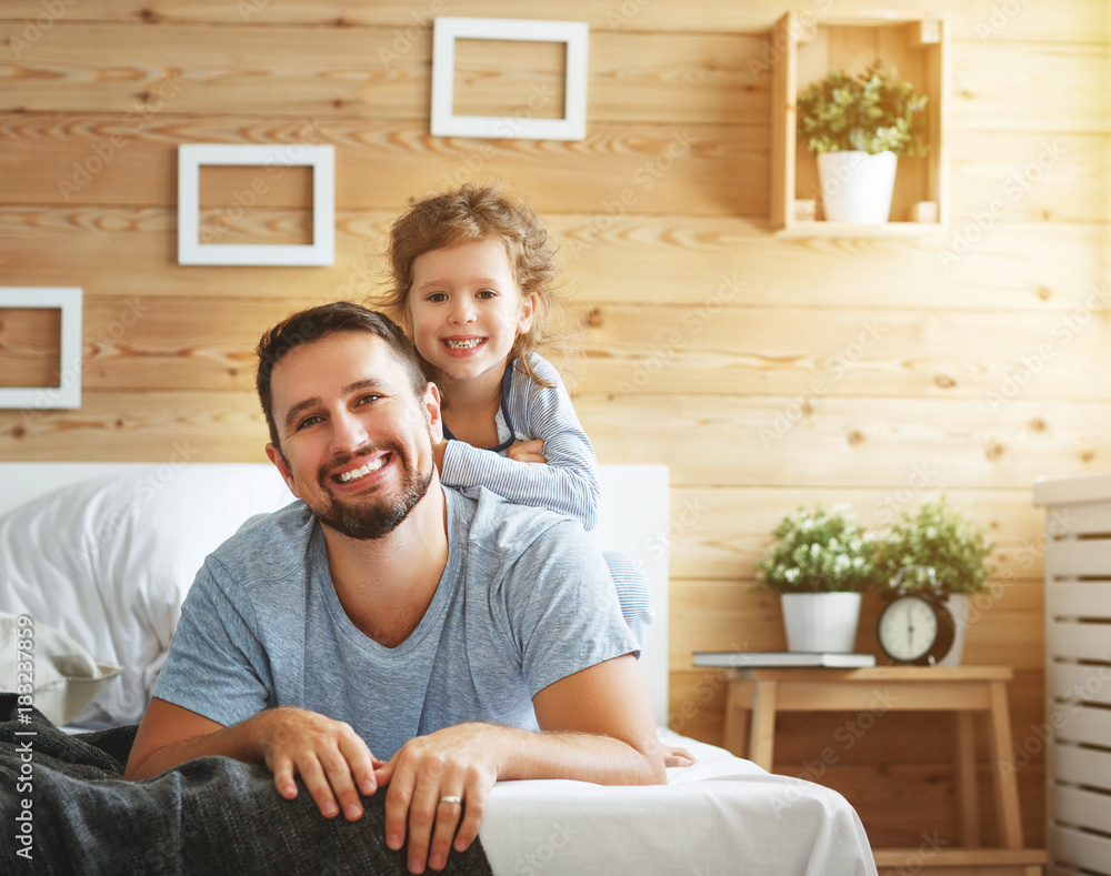 happy family father and   daughter laughing and playing in bed.