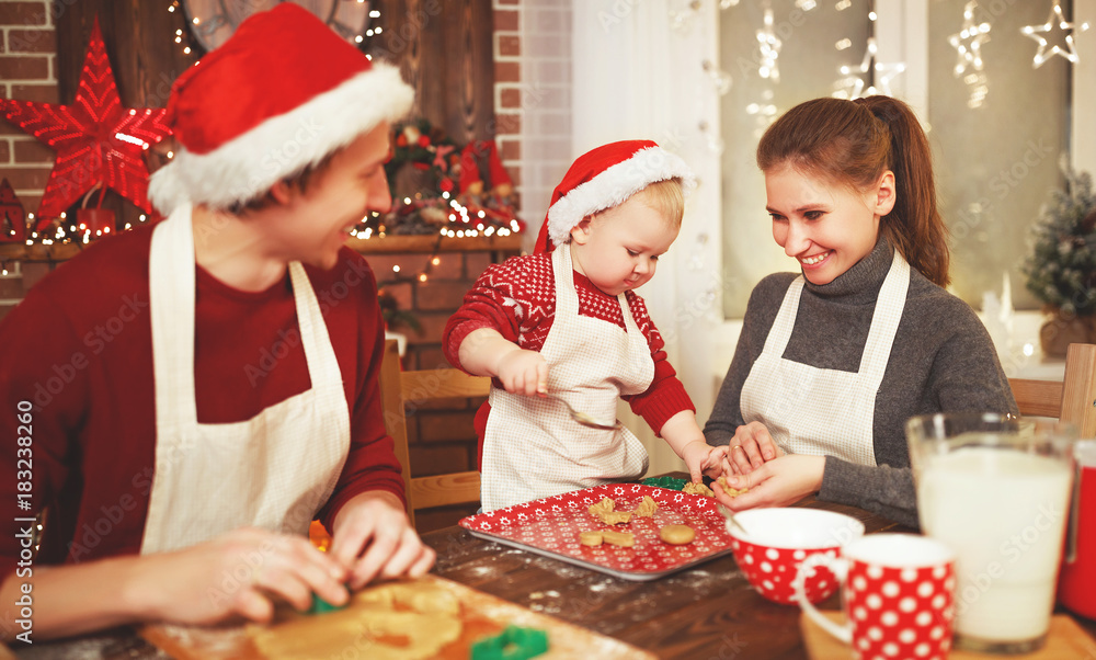 family mother father and baby bake christmas cookies.