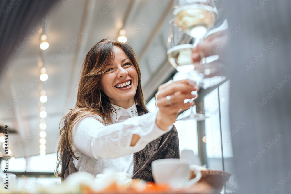 咖啡馆里一个深色女人和朋友碰杯。