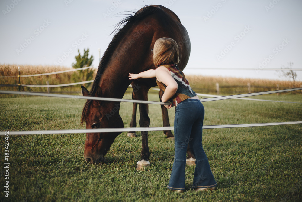 Little girl playing with a horse