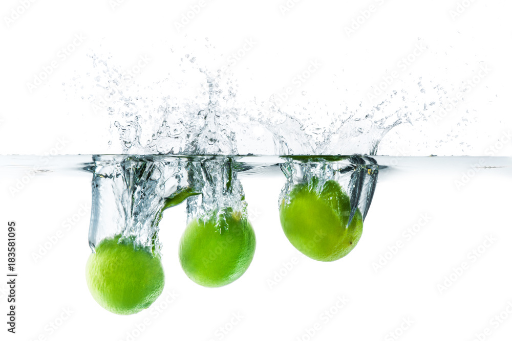 Fresh lime dropped into the water with water splash on a white background