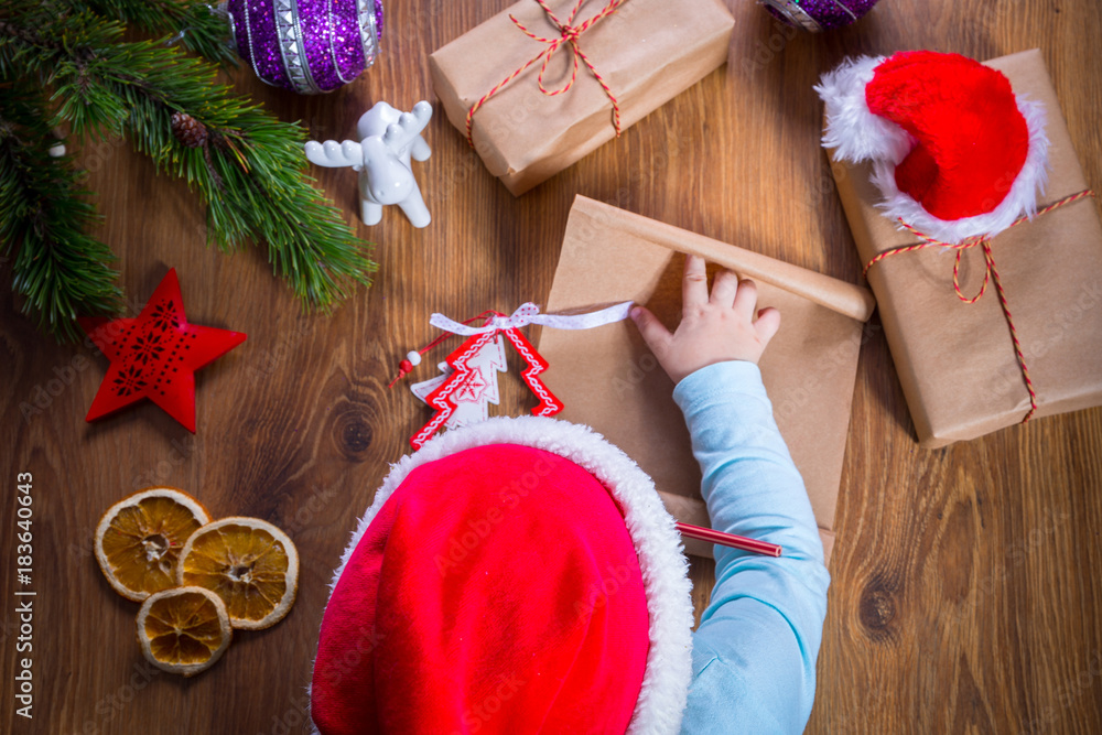 Top view of child writing letter to Santa Claus for Christmas