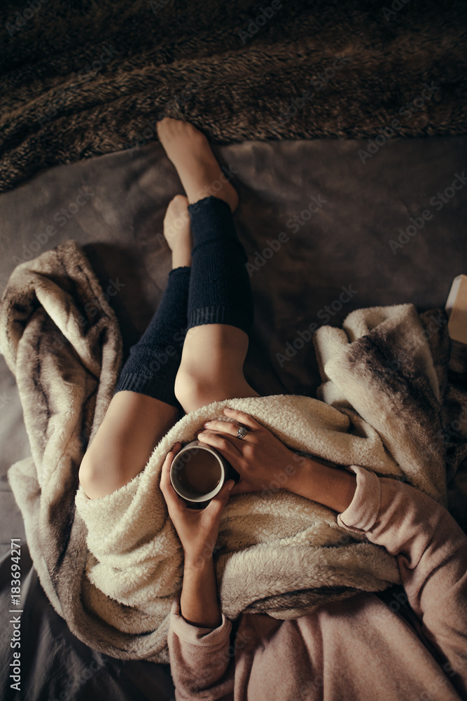 Woman lying on bed with a cup of coffee