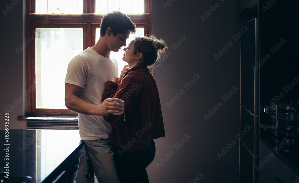 Affectionate young couple together in kitchen