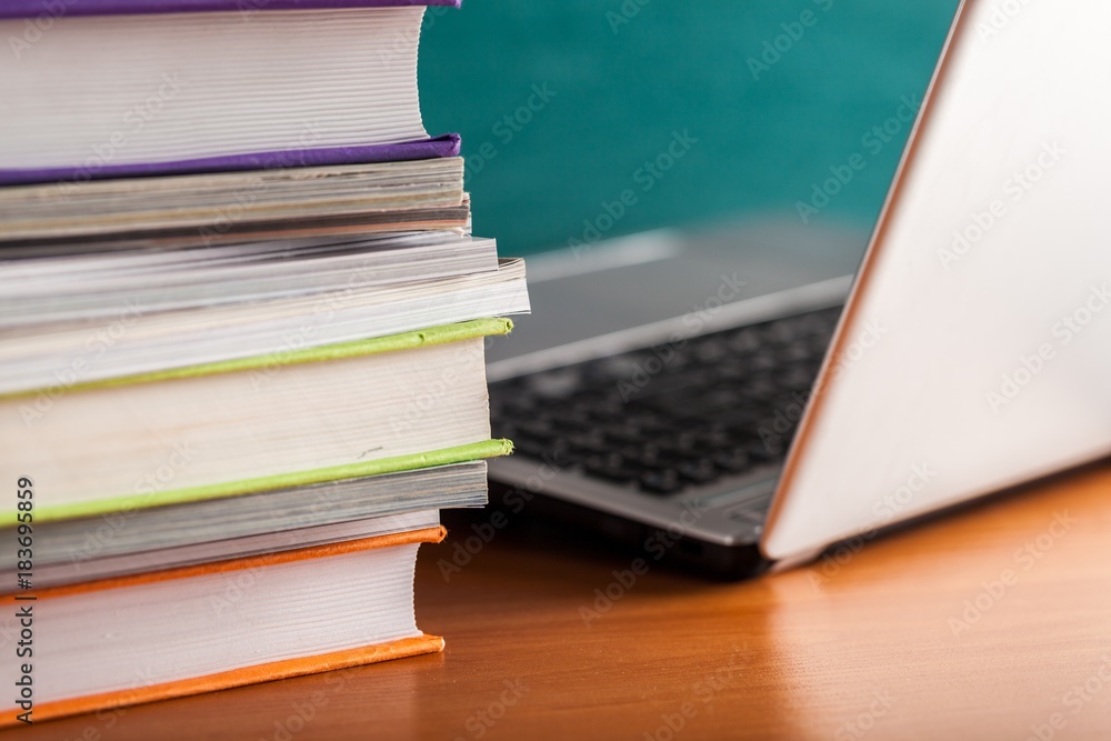 Stack of Books and Magazines with Laptop